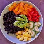 Bowl mit schwarzem Reis, Möhre, Paprika, Gurke, Mango und Avocado