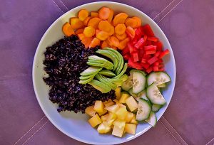 Bowl mit schwarzem Reis, Möhre, Paprika, Gurke, Mango und Avocado