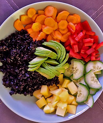 Bowl mit schwarzem Reis, Möhre, Paprika, Gurke, Mango und Avocado